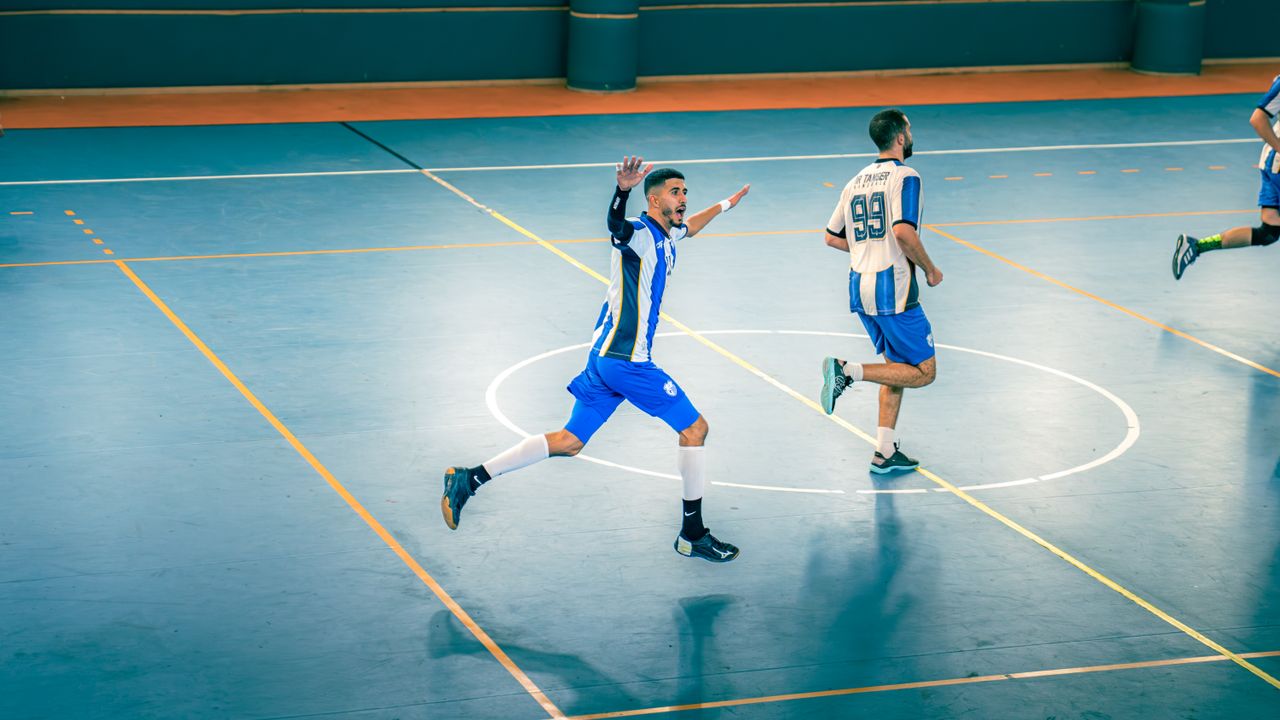 Action-packed indoor futsal game with players in motion on the court.